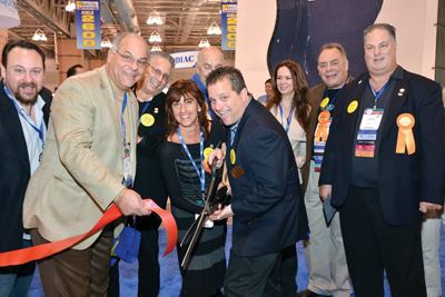 Show Chairman/NESPA Vice President Kyle

Chaikin (with scissors) kicks off the event with a ceremonial

ribbon cutting. He is joined by (L-R) Past President Rob Romano;

Treasurer John C. Migliaccio; APSP President Steve Gorlin; Long

Island Chapter Administrator Karen Pinto; immediate Past President

Clive Ensher; Nataliya Romano; APSP regional Director John Romano;

and President Robert Blanda.