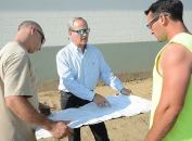 Building plans: Mike Giovanone (center) discusses the distribution center with two contractors.