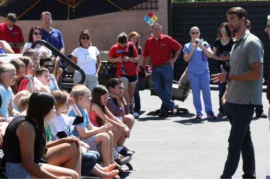 Michael Phelps speaks to approximately 30 children at a pool school held at Presidential Pools in Gilbert, Ariz.