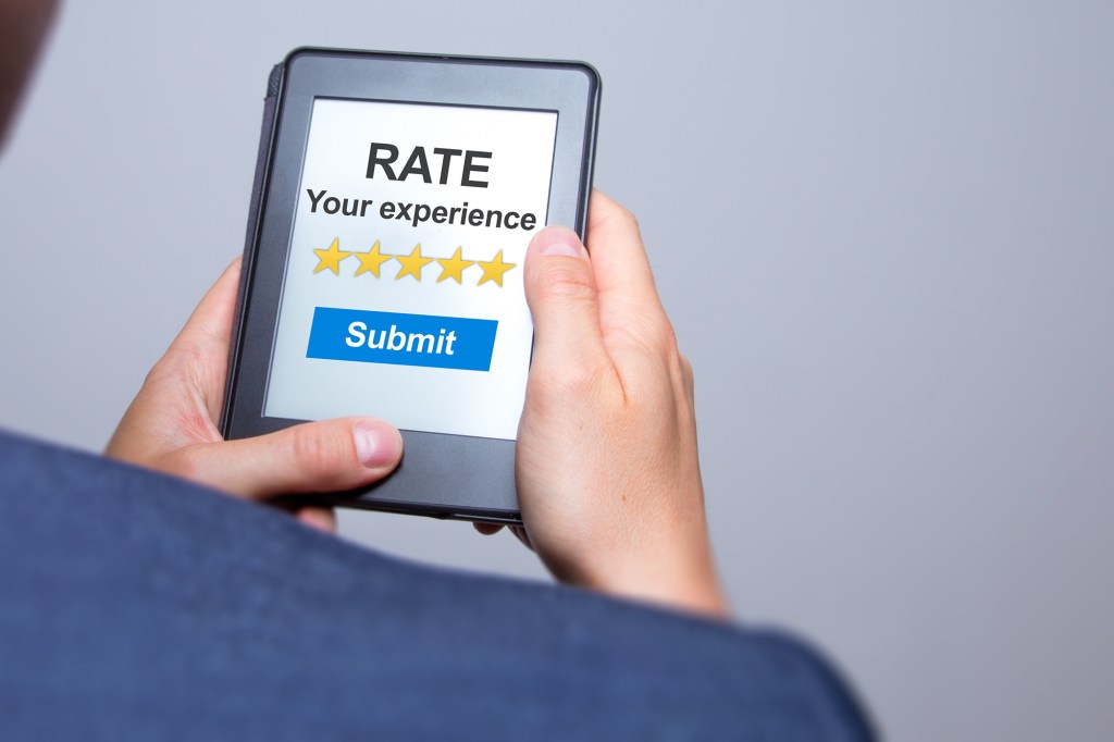 Businessman hands holding tablet with Rate your experience. Business concept.