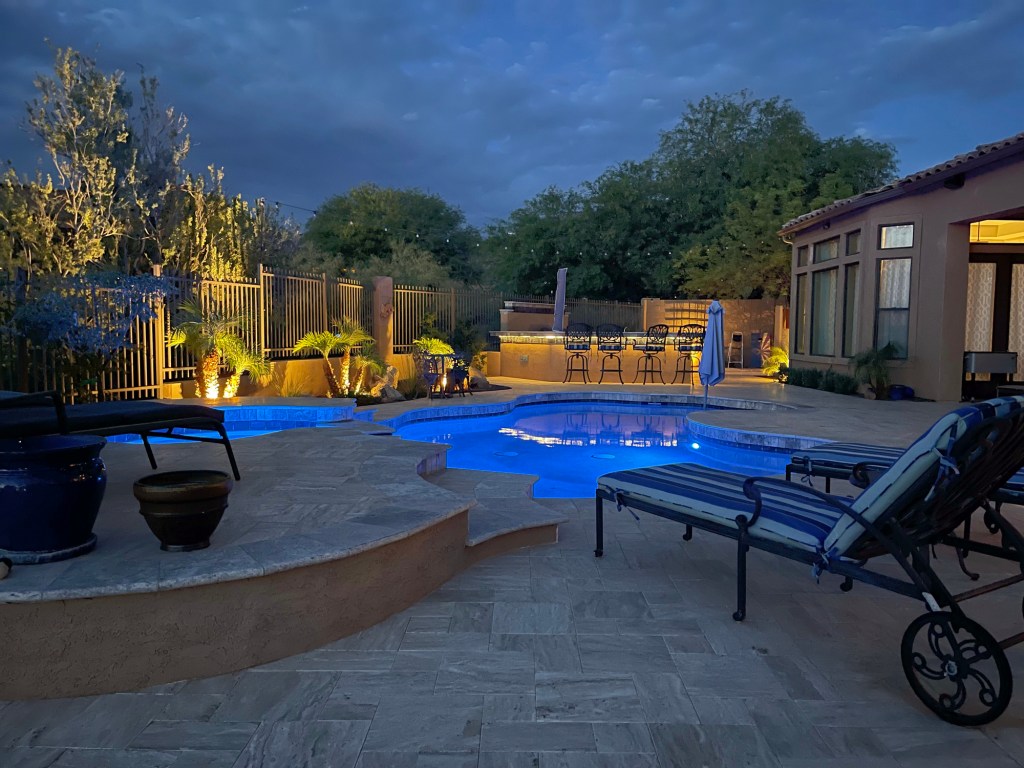 A desert landscaped yard in Arizona featuring a travertine pool deck.- Photo Courtesy of Richard Phillips