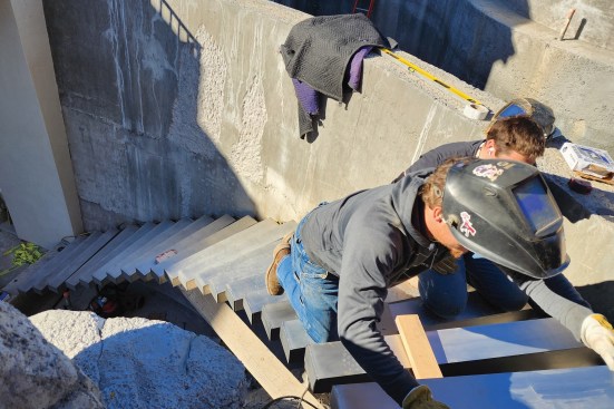 Floating stainless steel stairs leading into a lower catch basin.