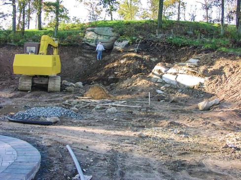 The granite outcropping seen above the worker remained in place in the finished installation, as did the ledge just below him and to his left. “The first step was to expose what was there,” says Giannamore, “then to finalize the design of the pool, to figure out what could be done with what was already there. Based on our experience with ledge, there was nothing we needed to do to stabilize it other than scrape and remove what was loose — which accounted for the first half a million hours or so!”