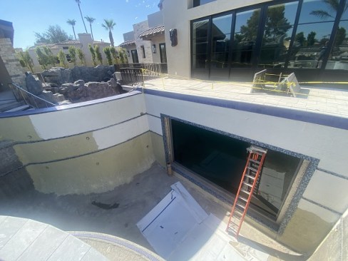 The shark tank window from the pool side, seen with the ladder in front of it.